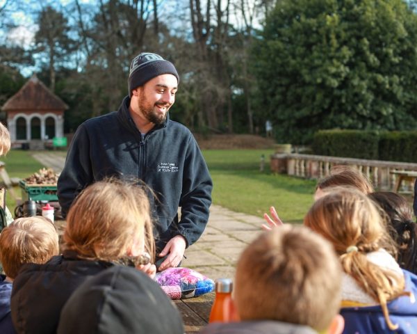 Avon Tyrrell instructor stood infront of group of young people in a forest