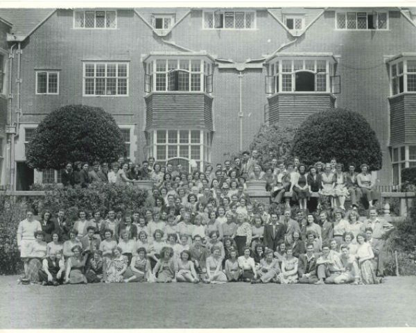 Group of people from a youth club sitting for a photo in front of the manor house at avon tyrrell - image is in black and whtie