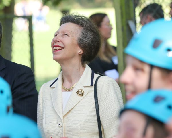 HRH Princess Anne, Nigel Mansel and Nidid Okezie stood smiling looking up