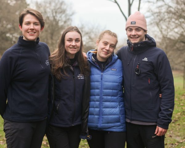 Group of avon tyrrell staff stood in the forest smiling to camera