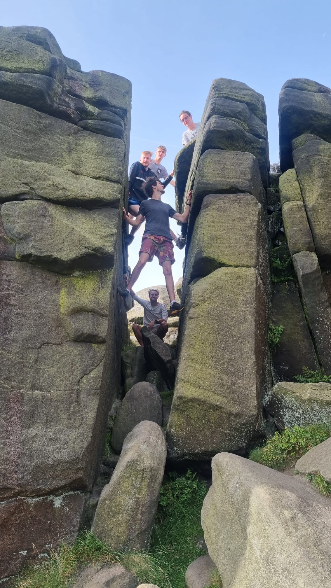 adults stood in rock structure smiling to camera