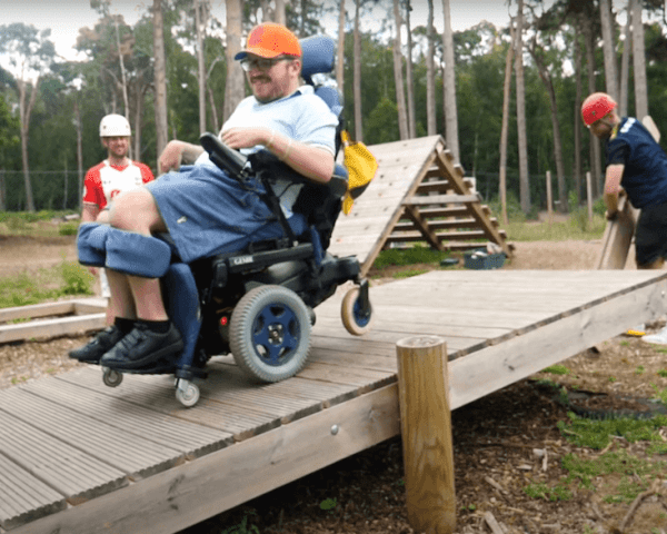 man in wheelchair on a moving ramp doing the challenge course at avon tyrrell