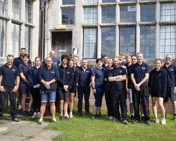 group of avon tyrrell staff outside of the manor house in the new forest