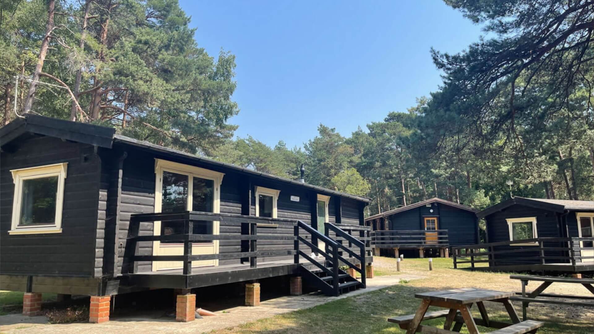 Lodge in the new forest at avon tyrrell with trees and nature - picnic bench and fire pit infront of lodge