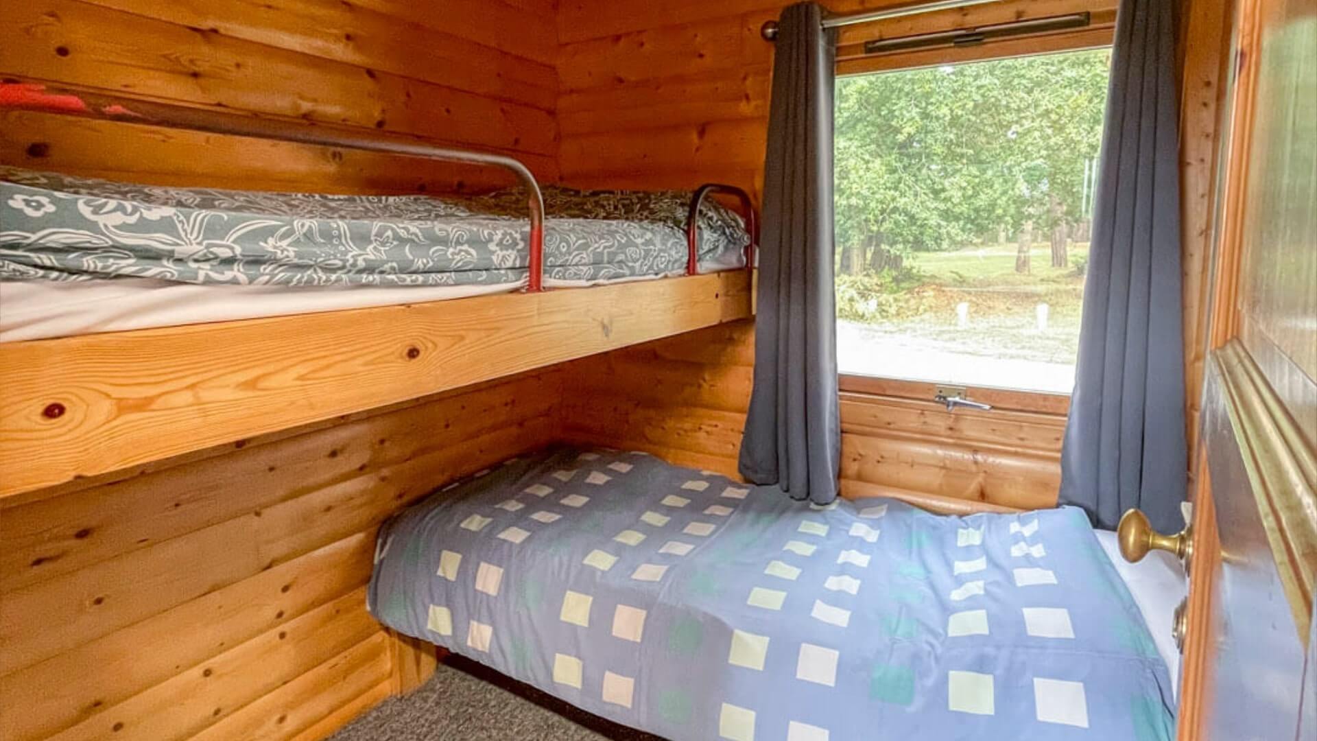 Single bunk beds in the wooden forest lodges at Avon Tyrrell Outdoor Centre