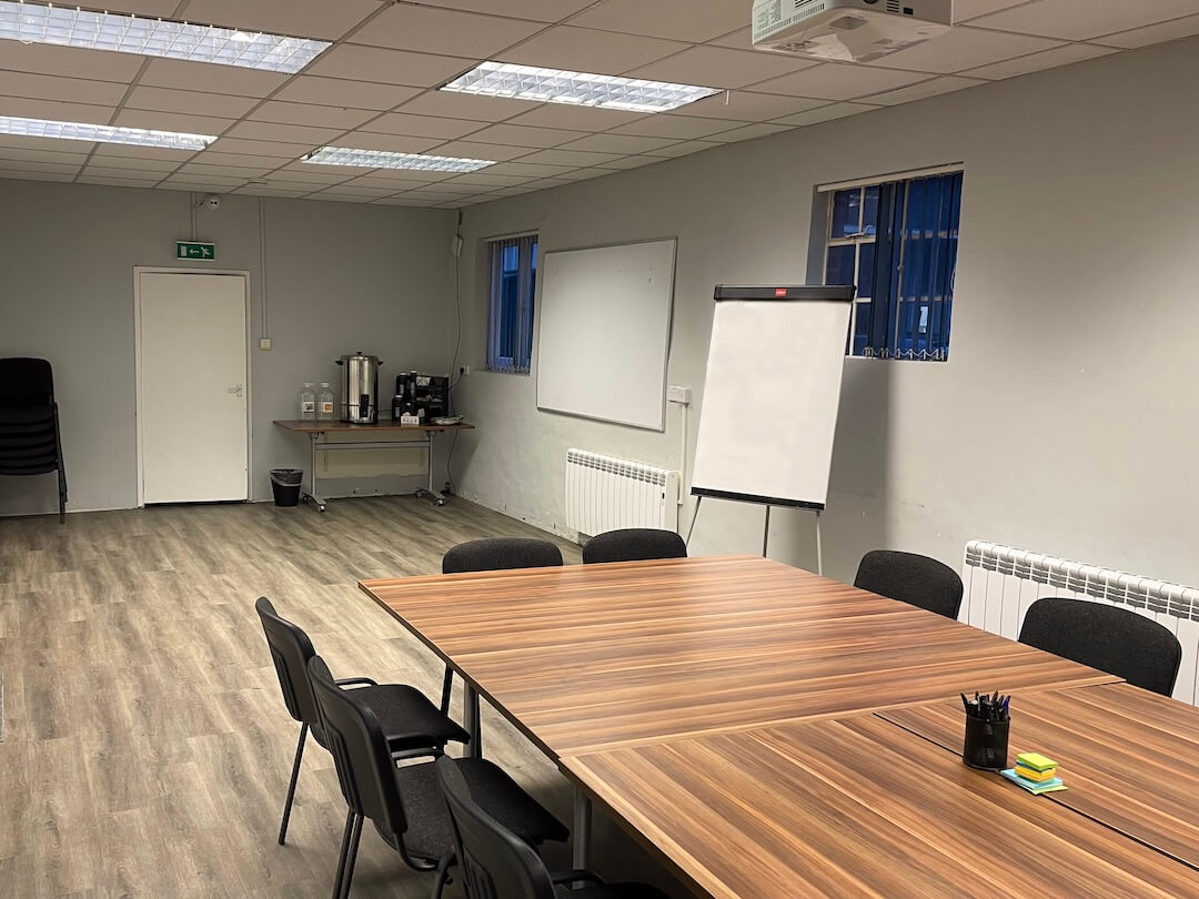 Inside of a training room at Avon Tyrrell with table and chairs, white board and tea or coffee facilities