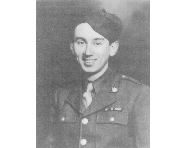 Black and whtie image of a UK WWI soldier wearing hat smiling to camerax