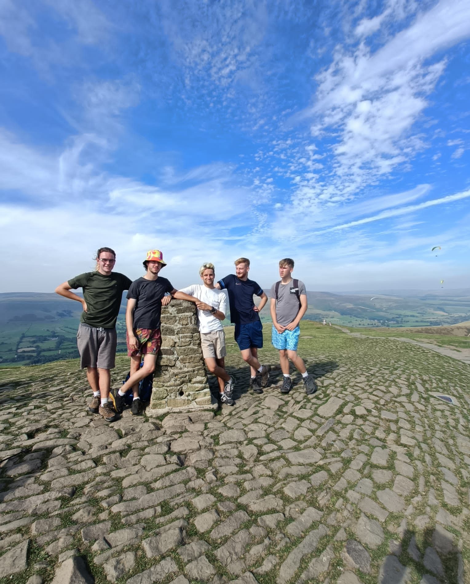 apprentices at the top of a peak smiling at camera
