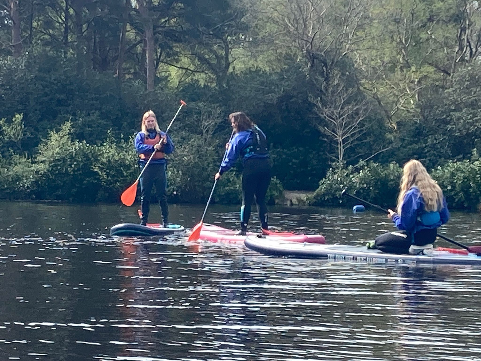 apprentices out on lake doing paddle boarding learning techniques in the new forest with Avon Tyrell Outdoor Centre